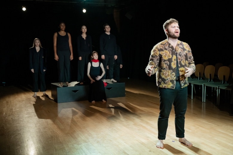 Male actor, in mid-speech, stands in front of another group of actors, during the fall 2023 final presentation of The Winter's Tale.